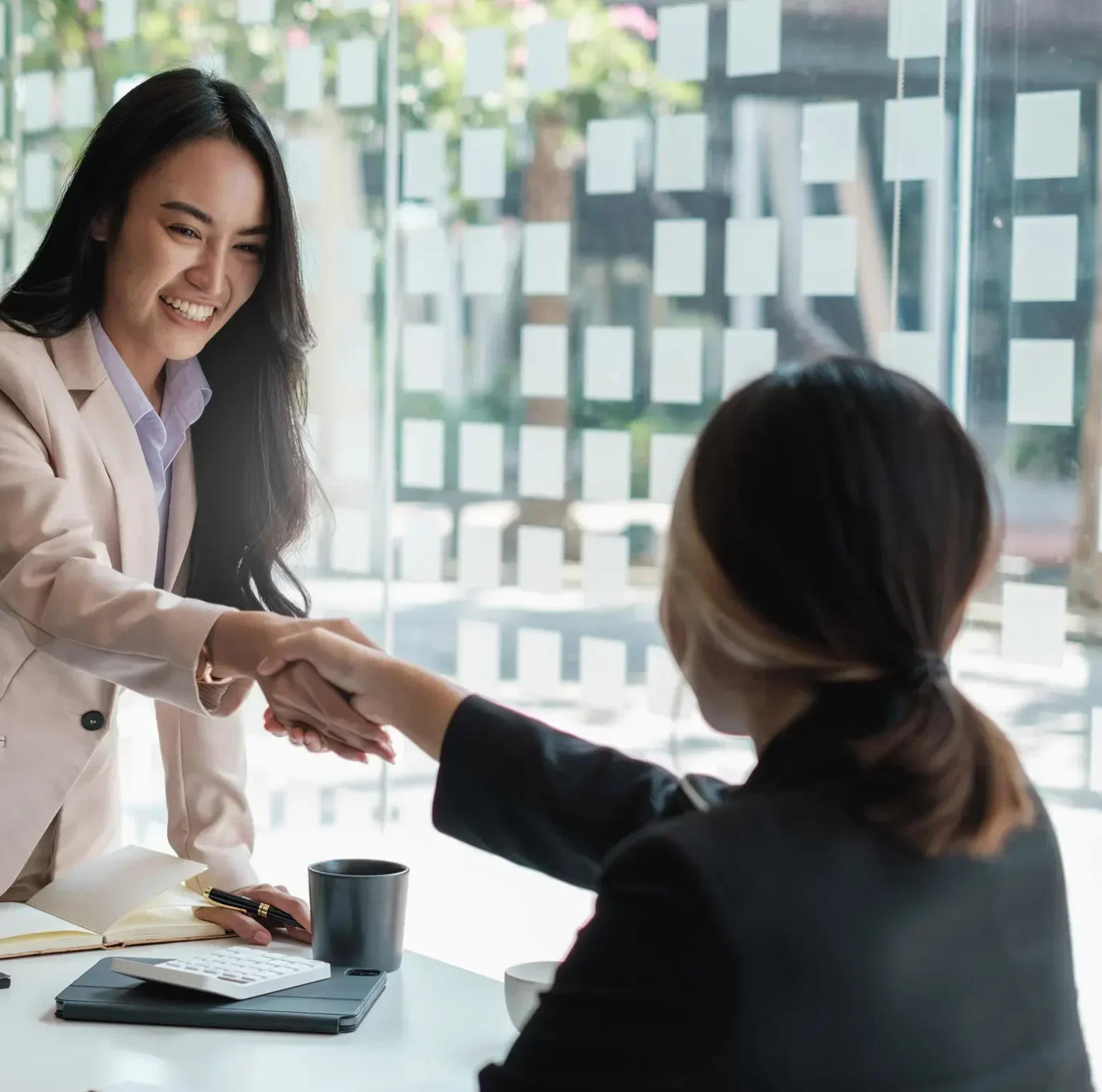 Investment manager greeting client with handshake after successful portfolio review meeting.